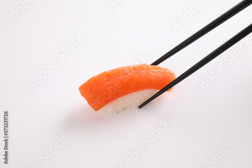Salmon sushi with chopsticks Japanese food isolated in white background