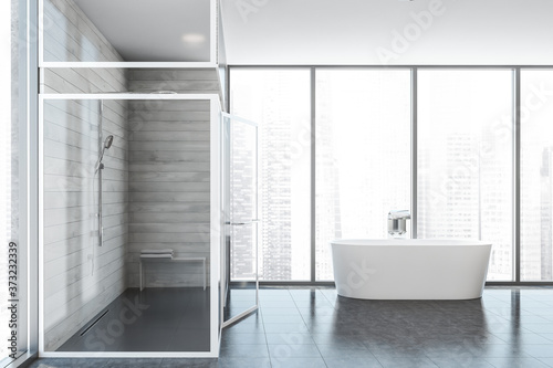 Bathtub and shower in white wooden bathroom