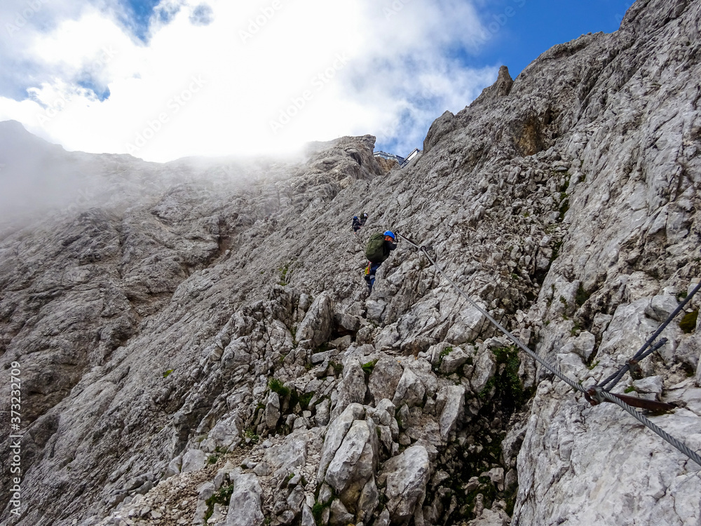 Man Hiking to the top of Germany with a stunning view to the alpine rocks in Germany