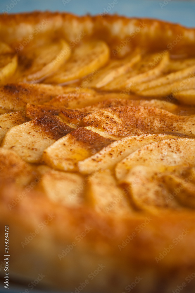 Homemade organic pie with apples puff pastry, cinnamon and butter. Delicious apple puff with blue background.