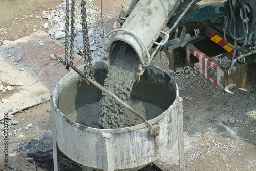 SELANGOR  MALAYSIA -JUNE 06  2016  Concrete mixer lorry pouring wet concrete into concrete bucket. 