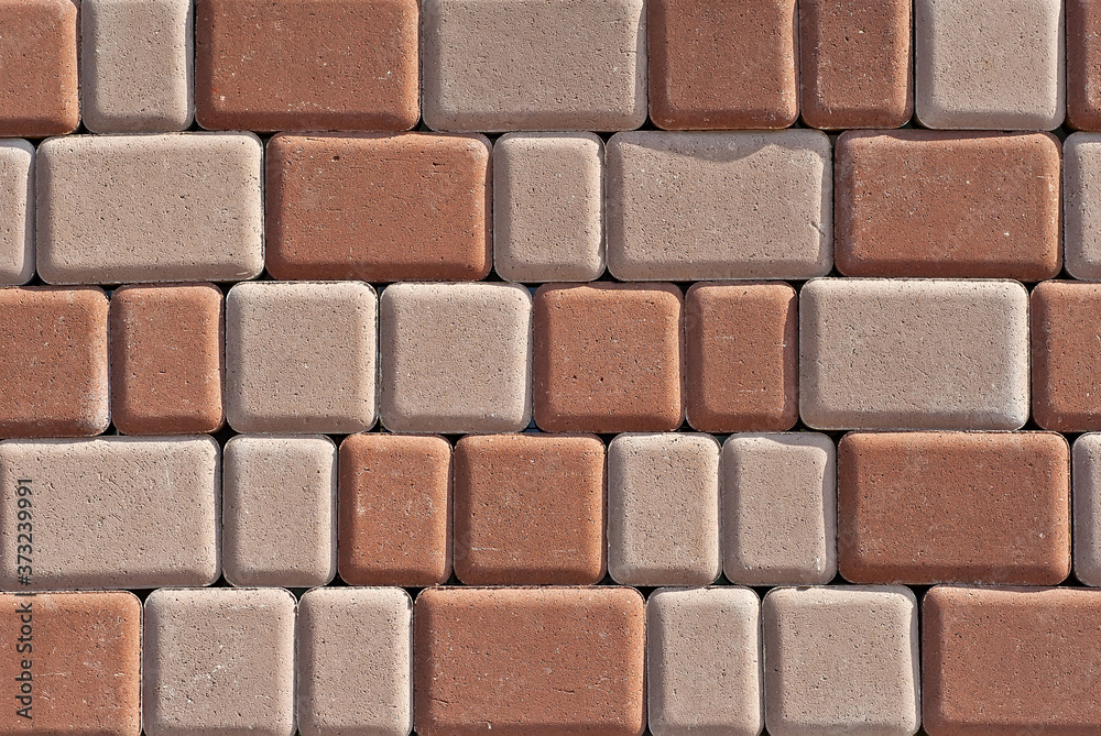 Fototapeta premium Cobblestone texture. The sidewalk tile is evenly folded. Brown cobblestones close up.