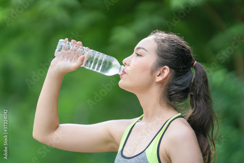 Beautiful girl drinking water after exercise.