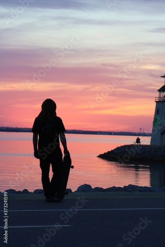silhouette of a woman on the pier at sunset