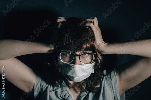 A woman with a mask experiencing anxiety  fear  anger  exhaustion and so many emotions due to the Covid 19 pandemic. 