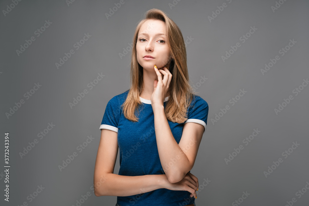 Thoughtful young female looking confident at the camera with hand raised on chin. Concept of thinking Thoughtful young female looking confident at the camera with hand raised on chin. Concept of thinking