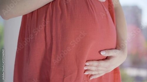 Wallpaper Mural Young female hands stroking pregnant belly. Angle view close-up of unrecognizable Caucasian expectant awaiting for childbirth at home. Happy pregnancy, femininity concept. Torontodigital.ca