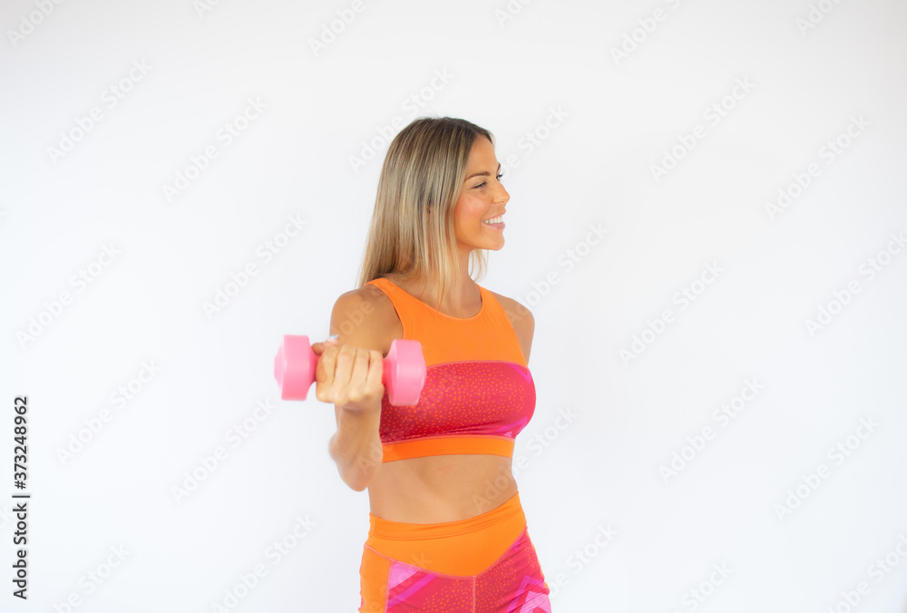 Smiling athlete woman with a dumbbell on white background Smiling athlete woman with a dumbbell on white background