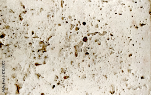 Foto texture uneven light gray warm tint concrete wall with small round holes backgro