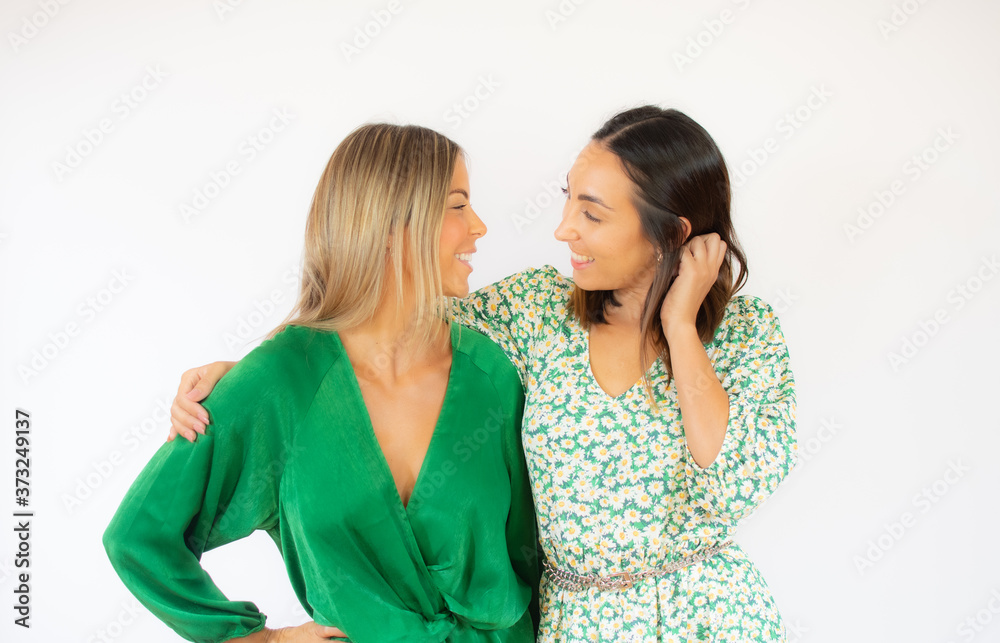 Two friends in green dresses pose together smiling Two friends in green dresses pose together smiling