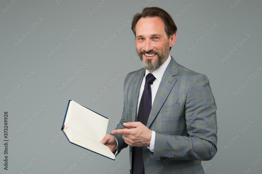 happy man in suit with book. accountant maintains accounting records. making notes in notebook. View the to-do list in his diary. University lecturer. mature man reading business literature