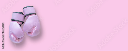 Breast cancer awareness concept with pink boxing gloves isolated (clipping path) for girl and woman fight with illness on pink background with copy space