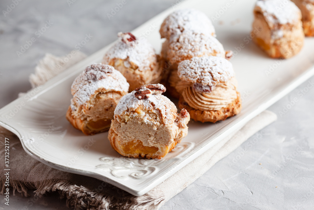 Classic French dessert eclair, choux pastry filled with soft hazelnut cream mango-passionfruit coulis Classic French dessert eclair, choux pastry filled with soft hazelnut cream mango-passionfruit coulis