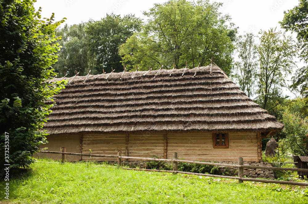Old authentic wooden house with a thatched roof Old authentic wooden house with a thatched roof