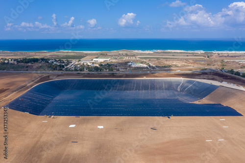 Water reservoir construction site with newly installed plastic lining sheets, Aerial view. © STOCKSTUDIO