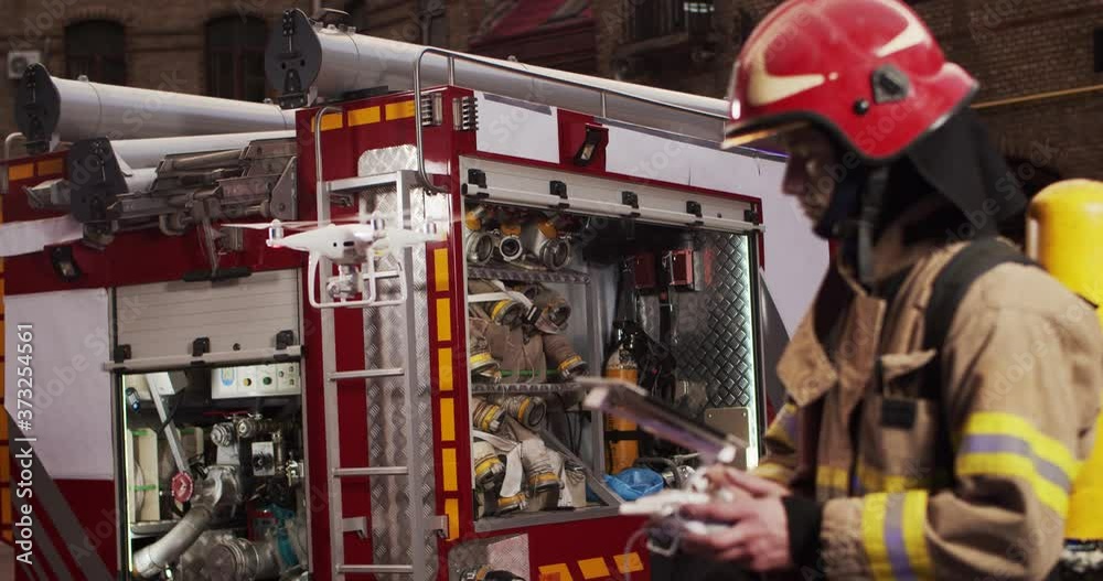 Portrait of firefighter adjusts drone holding control panel in hands to ...