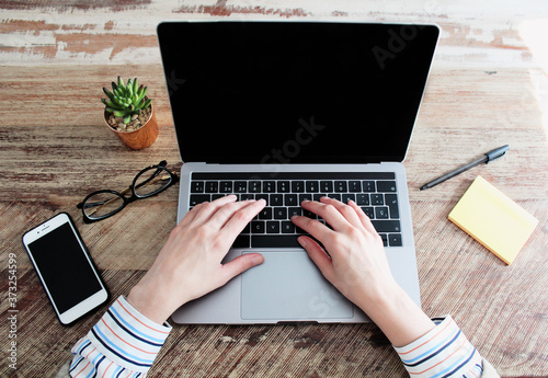 Woman working from home with laptop computer and smart phone, remote work, lockdown photo