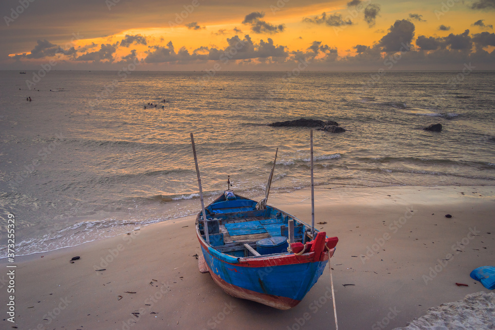 Old fisherman tradition wooden boat at sunrise time on the Bai Sau beach, Vung Tau, Vietnam.