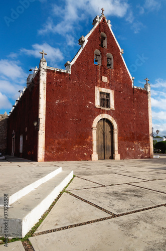 Catholic red colonial church Itzimna in a park, Merida, Yucatan, Mexico photo