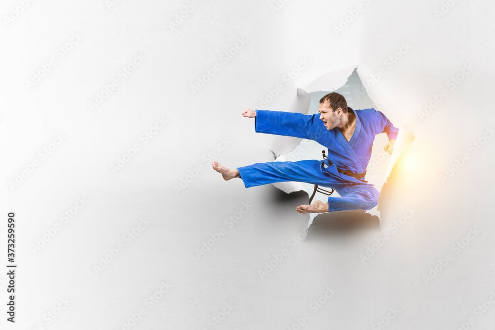 Fototapeta premium Young male practising karate . Mixed media