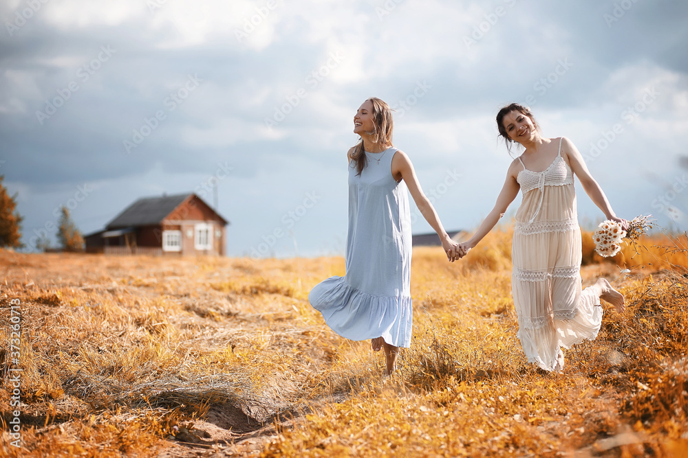 Two girls in dresses in autumn field Two girls in dresses in autumn field