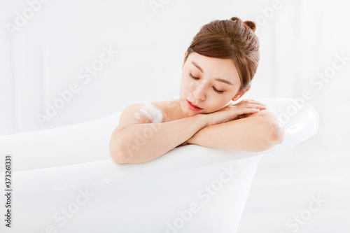 Beautiful young asian woman relaxing in bathtub
