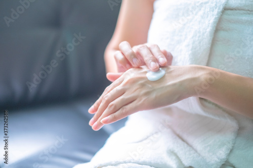 Asia woman applying moisturizing cream lotion on hands  beauty concept.