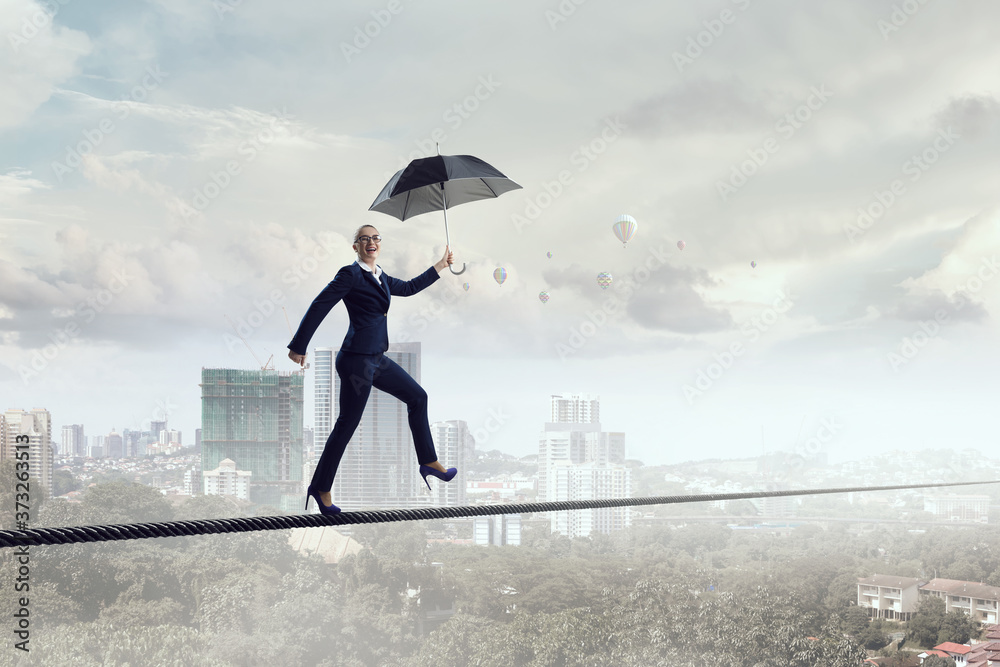 Young businesswoman walking with umbrella