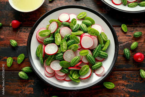 Cucamelon radish salad on rustic wooden table. healthy summer food