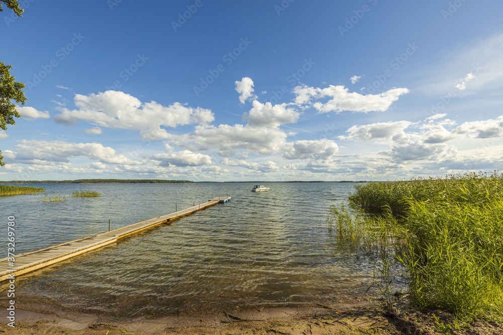 View of  Baltic Sea with  boat parked in shore on blue sky background. Beautiful backgrounds of nature landscape.