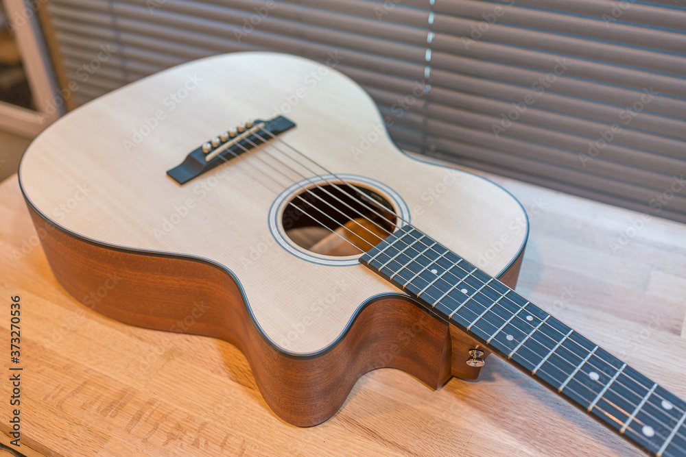 Fototapeta premium Acoustic guitar on wooden table in the room,Travel accessories concept