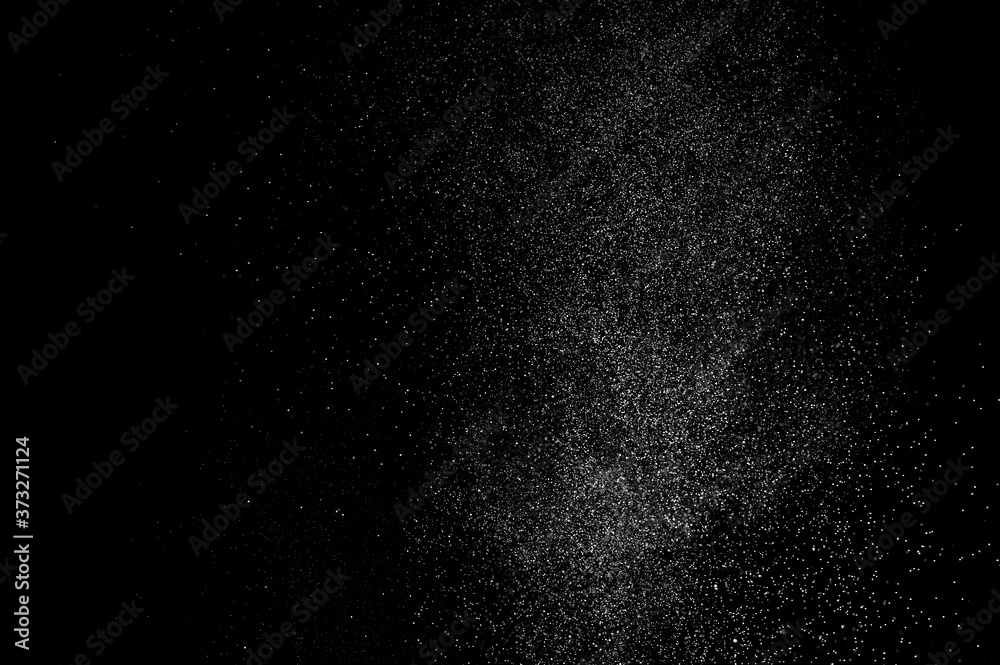 Abstract splashes of water on black background. Freeze motion of white particles. Rain, snow overlay texture.