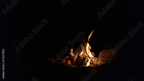Camp fire in the night. Bonfire.  Flame and fire sparks on dark background.  Black copy space.