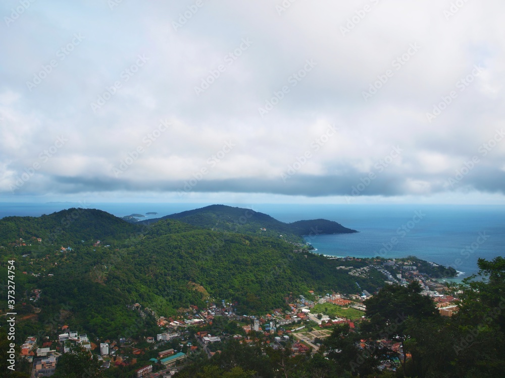 Nice panoramic view of the bay and islands. Sea view from the top of mountain. Panorama, seascape, green island. Hills covered with dense forest, the sky with storm clouds. Weather before rain