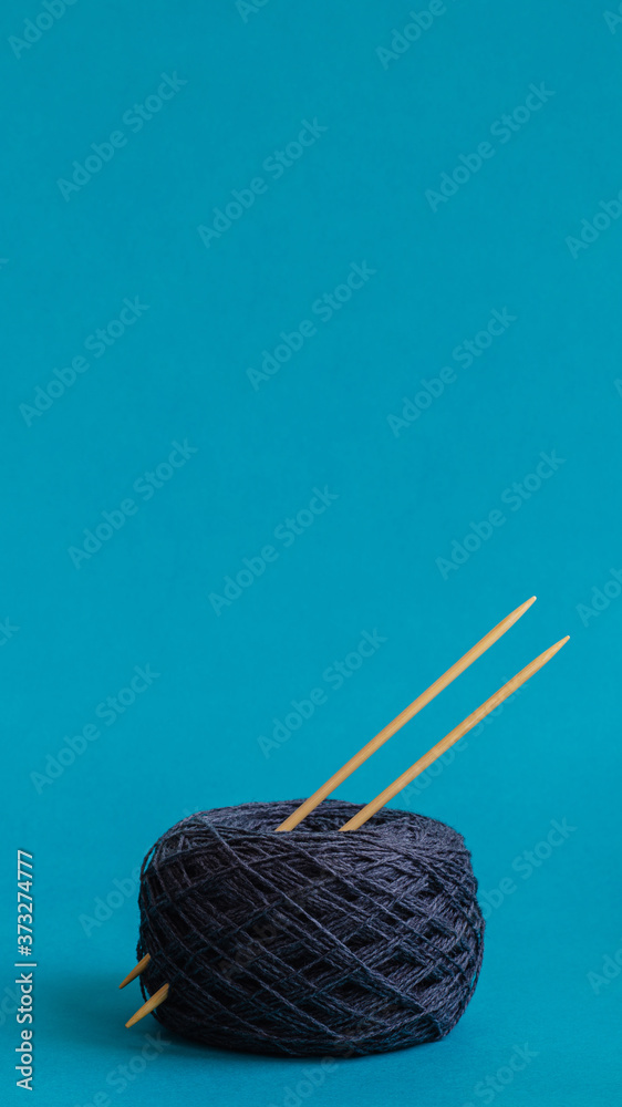 yarn ball of gray wool with knitting needles on turquoise background. copy space yarn ball of gray wool with knitting needles on turquoise background. copy space