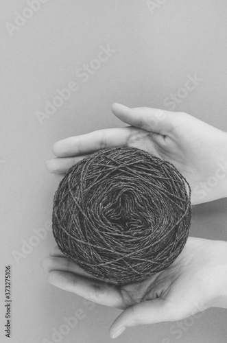 closeup female hands holding ball of wool yarn ball. black and white shot