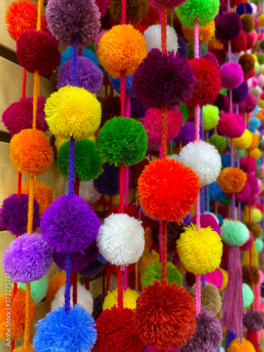 Abstract bright background.Vivid different colors balls of threads. The texture of the fluffy balls. Beautiful bright background. Vertical, close-up.