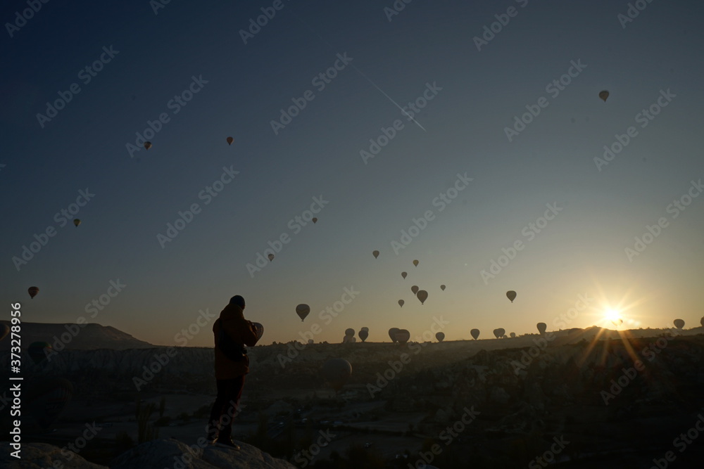 Hot air balloon flying over rock landscape at Cappadocia Turkey Hot air balloon flying over rock landscape at Cappadocia Turkey