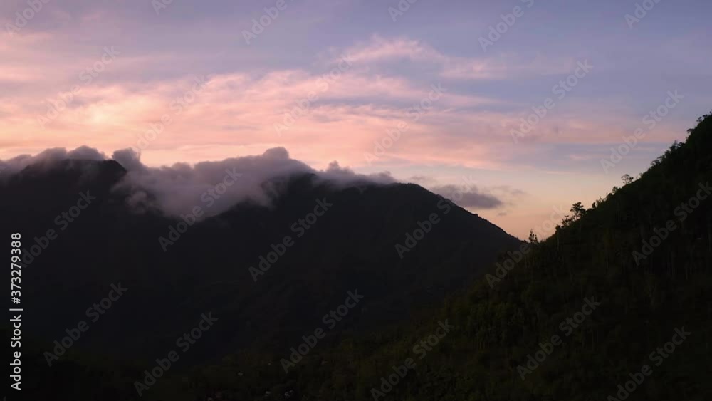 Dark mountains during dawn in Bali with breathtaking colorful sky, aerial Dark mountains during dawn in Bali with breathtaking colorful sky, aerial
