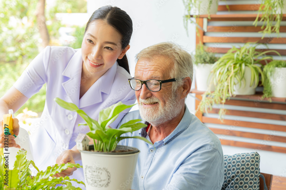 Senior retirement man and nurse are watering a small plant while relax at home Senior retirement man and nurse are watering a small plant while relax at home