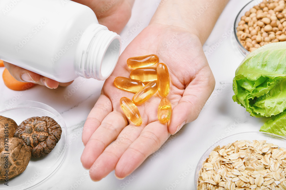 Obraz premium Vitamin nutrition pills on hand, Natural medicine supplement from organic fresh fruit, wholegrain cereals and vegetable, Healthy beauty food diet.