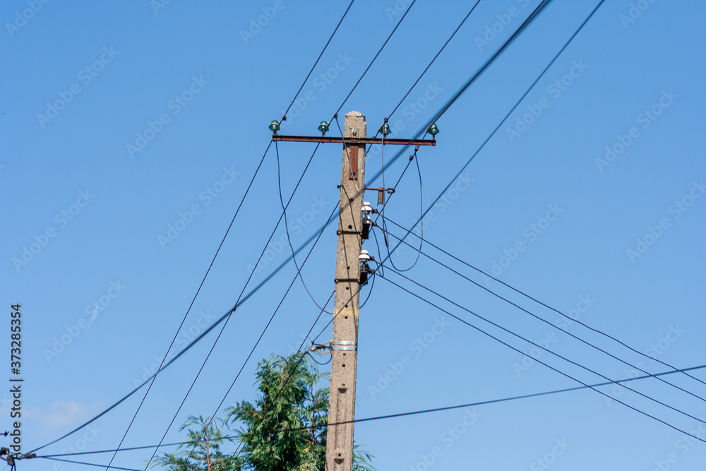 Old energy pole with four line in Poland. Electricity price concept background Old energy pole with four line in Poland. Electricity price concept background