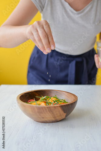 Fototapeta Naklejka Na Ścianę i Meble -  woman cooking healthy salad in a bowl