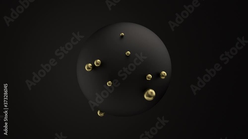 Small golden balls covering and moving on matt surface of huge black sphere isolated photo