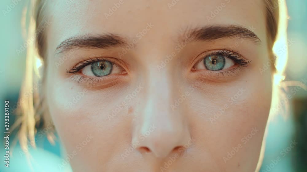 At sunlight face young beautiful woman with blue eyes smiling look at camera outdoors beauty macro natural girl hair eyes human eyebrow slow motion