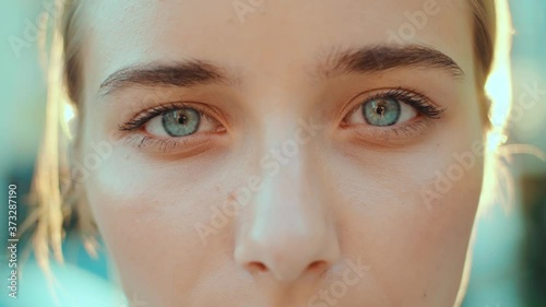 At sunlight face young beautiful woman with blue eyes smiling look at camera outdoors beauty macro natural girl hair eyes human eyebrow slow motion