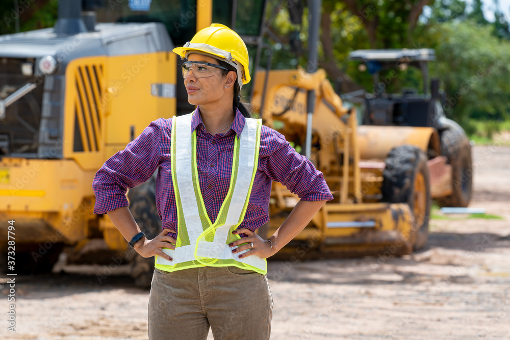 Portrait of confident female architect wearing hard hat and reflective vest at construction site. Portrait of confident female architect wearing hard hat and reflective vest at construction site.