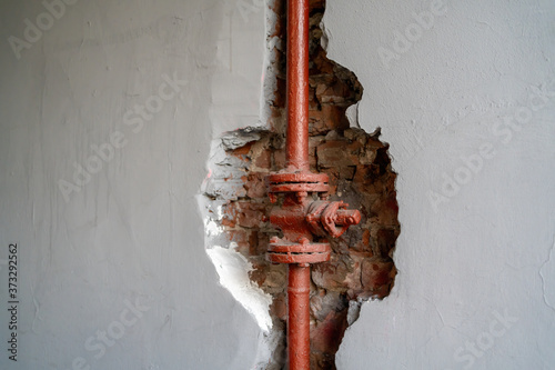 фотографія The pipe is red in the wall. A niche out in a brick wall.