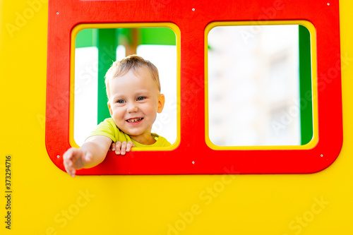 happy little boy playing on the Playground, boy looking out of the window, children's lifestyle