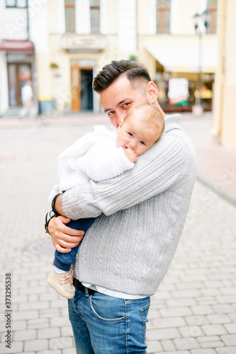 Hipster father holding baby. Family portrait in the city. Father with a child for a walk. © Евгений Гвоздев